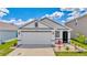 Charming single-story home with a two-car garage, manicured lawn, and landscaped garden at 16892 Delia St, Wimauma, FL 33598