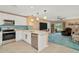 Kitchen view into the living room with sliding glass door out to the lanai at 16892 Delia St, Wimauma, FL 33598