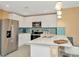 Bright kitchen features stainless steel appliances, white cabinets, breakfast bar and decorative lighting at 16892 Delia St, Wimauma, FL 33598