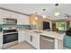 Kitchen with stainless steel appliances, white cabinets and countertops with bar overlooking the Gathering room at 16892 Delia St, Wimauma, FL 33598