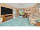 Spacious living room showcasing the television and sliding glass door to the lanai at 16892 Delia St, Wimauma, FL 33598