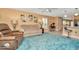 Inviting living room with large blue rug, sofa, recliner, and interior view into the kitchen at 16892 Delia St, Wimauma, FL 33598