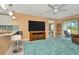 Open-concept living room showcasing a television, access to the lanai, and a barstool seating area at 16892 Delia St, Wimauma, FL 33598