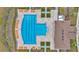Aerial view of a community pool with lounge chairs and landscaped surroundings, next to clubhouse at 16892 Delia St, Wimauma, FL 33598