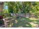 Lush backyard with a shed, tall trees, and wood fence, offering a private and serene outdoor space at 1726 York S St, Gulfport, FL 33707