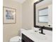 Well-lit half bathroom showcasing a dark vanity, white sink, modern faucet, and framed mirror at 1726 York S St, Gulfport, FL 33707