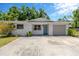 Charming single-story home with stone accents, a well-maintained lawn, and a concrete driveway leading to an attached garage at 1726 York S St, Gulfport, FL 33707