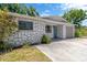 Charming single-story home boasts stone accents, a well-maintained lawn, and an attached garage with a concrete driveway at 1726 York S St, Gulfport, FL 33707