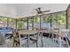 Enclosed patio featuring a ceiling fan, dining set, and cushioned seating for outdoor relaxation and entertaining at 1726 York S St, Gulfport, FL 33707