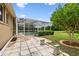 A tiled patio leads to a screened pool and beautiful backyard at 19106 Beckett Dr, Odessa, FL 33556