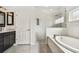 Elegant bathroom with a soaking tub, glass-enclosed shower, and stylish vanity with dark wood cabinets at 19106 Beckett Dr, Odessa, FL 33556