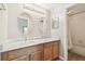 Bright bathroom featuring a double sink vanity with dual mirrors and separate bath area at 19106 Beckett Dr, Odessa, FL 33556