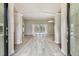 Spacious living room featuring light wood floors, columns, and sliding glass doors to the pool area at 19106 Beckett Dr, Odessa, FL 33556