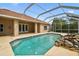 Sparkling pool with rock waterfall, complemented by a covered patio, creating a relaxing backyard oasis at 19106 Beckett Dr, Odessa, FL 33556
