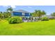 An expansive backyard with a well-maintained lawn and a charming blue home with a delightful pool at 19620 Eagle Crest Dr, Lutz, FL 33549
