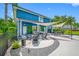 Landscaped backyard featuring a covered patio, an outdoor fire pit, dining area, and lush greenery at 19620 Eagle Crest Dr, Lutz, FL 33549