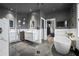 Modern bathroom featuring dual sinks, a sleek tub, and a glass-enclosed shower with gray walls and tile flooring at 19620 Eagle Crest Dr, Lutz, FL 33549