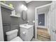 Charming bathroom featuring a white sink vanity, white toilet and hardwood flooring leading to another room at 19620 Eagle Crest Dr, Lutz, FL 33549