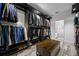 Spacious walk-in closet with custom dark wood shelving, organized clothing racks, and a central storage bench at 19620 Eagle Crest Dr, Lutz, FL 33549