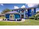 Stunning two-story home showcasing a vibrant blue exterior, elegant architectural details, and manicured landscaping at 19620 Eagle Crest Dr, Lutz, FL 33549