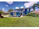 Bright blue two-story home featuring a well-manicured lawn and ornate architectural details at 19620 Eagle Crest Dr, Lutz, FL 33549