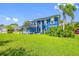 Bright blue home with manicured lawn and lush landscaping on a sunny day at 19620 Eagle Crest Dr, Lutz, FL 33549