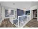 Bright hallway with hardwood floors, a decorative light fixture and a stairway with white banisters at 19620 Eagle Crest Dr, Lutz, FL 33549
