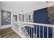 Upstairs hallway with white railings, wood floors, and decorative wall art at 19620 Eagle Crest Dr, Lutz, FL 33549