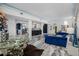 Bright living room featuring a blue velvet sofa, modern table, and unique flooring at 19620 Eagle Crest Dr, Lutz, FL 33549