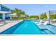 Beautiful pool with clear water, white floating loungers, an outdoor dining area, and a gazebo with privacy curtains at 19620 Eagle Crest Dr, Lutz, FL 33549