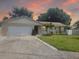 Well-maintained one-story home with a two-car garage, palm tree, and a green front lawn at 2278 Republic Dr, Dunedin, FL 34698