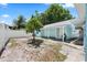 View of the backyard with a white fence, tree, and pale blue exterior on the home at 2306 W Ivy St, Tampa, FL 33607