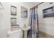 Bathroom with a pedestal sink, toilet, shower with curtain, and decorative wall art at 2306 W Ivy St, Tampa, FL 33607