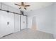 Bedroom with tile flooring, barn doors, and ceiling fan at 2306 W Ivy St, Tampa, FL 33607