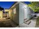 Exterior view of the home featuring light-blue stucco walls and a white door with concrete steps at 2306 W Ivy St, Tampa, FL 33607