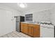 A compact kitchen features wood cabinets, white appliances, and a stainless steel refrigerator at 2306 W Ivy St, Tampa, FL 33607