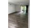 Bright living room featuring hardwood floors and a sliding glass door to the outside at 2650 Countryside Blvd # C106, Clearwater, FL 33761