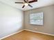 Neutral bedroom with light walls, wood floors, ceiling fan, and a window with exterior views at 2707 Lakeville Dr, Tampa, FL 33618