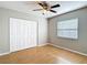 Bright bedroom featuring a ceiling fan, wood floors, closet, and a window with blinds at 2707 Lakeville Dr, Tampa, FL 33618