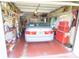 View of a car in a garage with storage on shelves and a red floor at 2854 60Th N St, St Petersburg, FL 33710