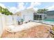 A pool and surrounding gravel, stepping stones, and white lattice fence can be seen from the backyard at 2854 60Th S St, St Petersburg, FL 33710