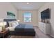 Modern bedroom with plush carpeting, large window, and sleek furniture arrangement at 2882 Peony Prairie Ln, Wesley Chapel, FL 33543
