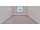 Bedroom featuring neutral colored carpet, a window for natural light, and white trim at 2882 Peony Prairie Ln, Wesley Chapel, FL 33543