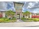 Exterior shot of community clubhouse entrance featuring stone facade and tropical landscaping at 2882 Peony Prairie Ln, Wesley Chapel, FL 33543