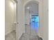 Hallway featuring an arched entryway, neutral walls, and tile flooring at 2882 Peony Prairie Ln, Wesley Chapel, FL 33543