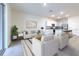Open-concept living room showcasing contemporary design and stainless steel kitchen appliances at 2882 Peony Prairie Ln, Wesley Chapel, FL 33543