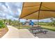Community playground under a shaded canopy with picnic table and walking path at 2882 Peony Prairie Ln, Wesley Chapel, FL 33543