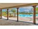 A view of the community pool with lounge chairs and palm trees from the covered patio at 2882 Peony Prairie Ln, Wesley Chapel, FL 33543