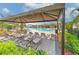 Relaxing pool area with lounge chairs under a shaded canopy, perfect for sunny days at 2882 Peony Prairie Ln, Wesley Chapel, FL 33543