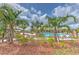 Community pool surrounded by palm trees, lounge chairs, and landscaping at 2882 Peony Prairie Ln, Wesley Chapel, FL 33543